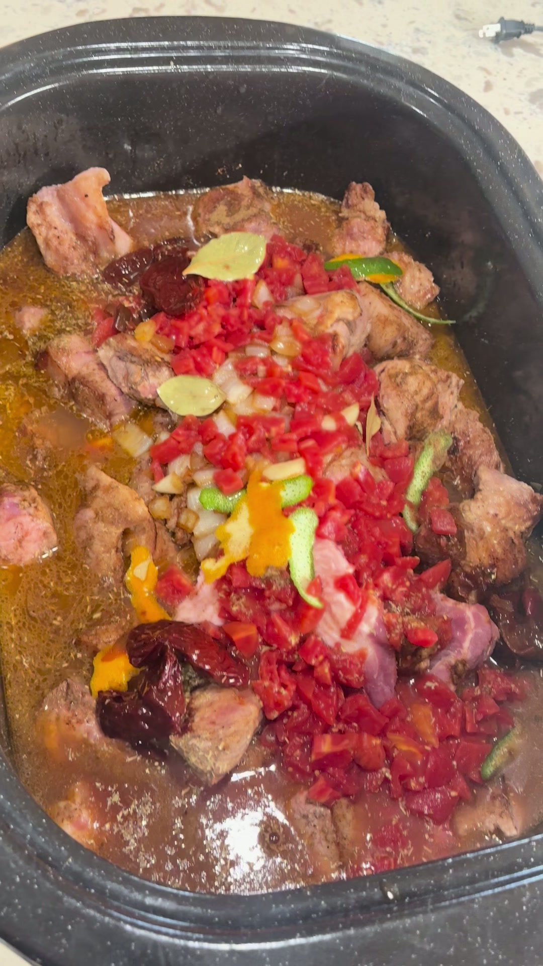 Fully assembled braise: pork, tomatoes, chipotles, citrus and stock ready to cook